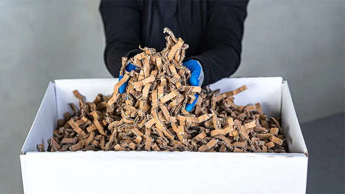 Relleno de embalaje con chips de cartón reciclado Fabricación de chips de cartón para envases y material de relleno. Los chips de cartón estabilizan la mercancía en el envase, rellenan los espacios vacíos y amortiguan los impactos, y todo ello sin plástico.