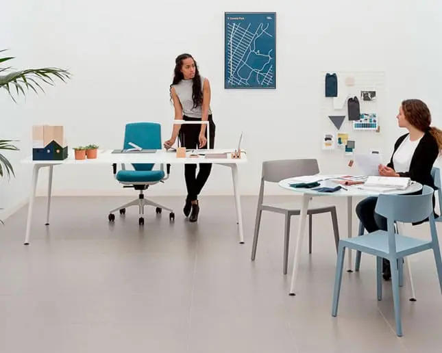 Mesa Twist resistente con patas de aluminio macizo Mujer trabajando en mesa Twist con estructura robusta y superficie duradera