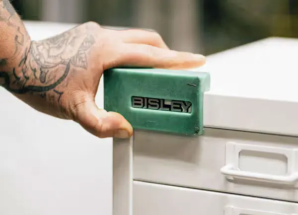 Mano tatuada marcando archivador con el logo de Bisley