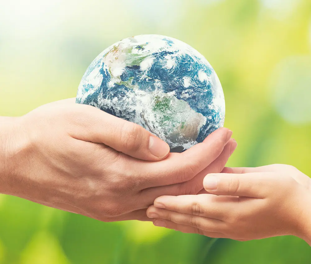 Compromiso medioambiental en destructoras HSM OMDD 130 Manos sosteniendo un planeta como símbolo del compromiso ambiental de HSM