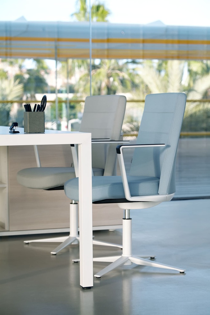 Mesa Prisma de Actiu con diseño nórdico en blanco con asientos Cron y apoyo en armario de archivo